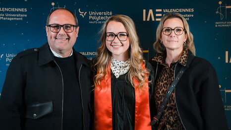 Une diplômée et ses proches posent devant le photocall lors de la cérémonie de remise de diplômes