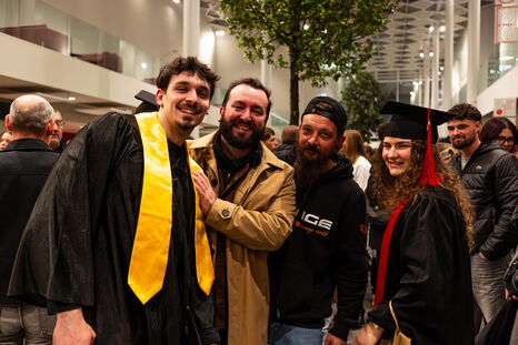 Des diplômés posent avec leurs proches dans le hall de la Cité des Congrès