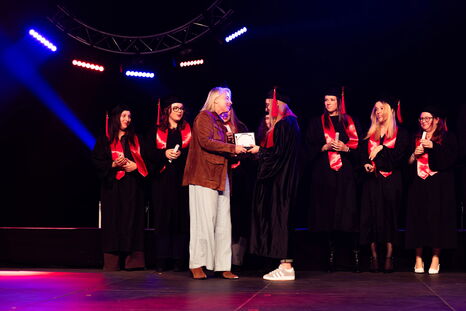 Une responsable pédagogique de formation remet un trophée à l'un des majors de promotion
