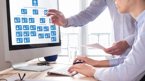 2 personnes consultant un organigramme sur un ordinateur