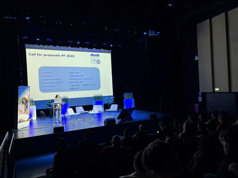 Conférence dans un auditorium avec des étudiants assis et une intervenante